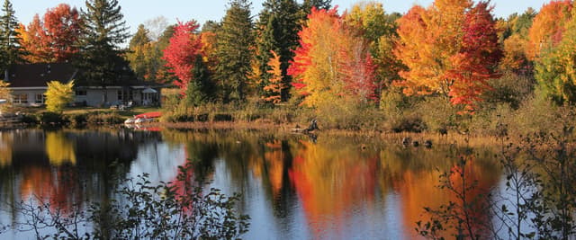 Autumn cabin reflected in a Northern Wisconsin lake surrounded by fall foliage