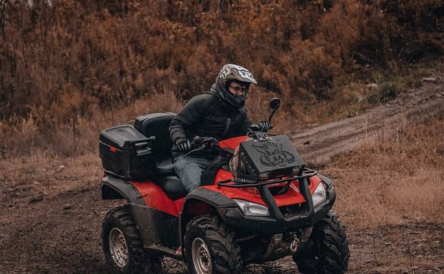 ATV rider on a muddy trail through autumn forest in Northern Wisconsin